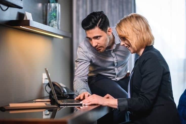 Compatible Businesspeople Working Together in Hotel Room