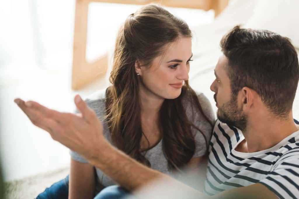 Happy young couple talking to each other at home