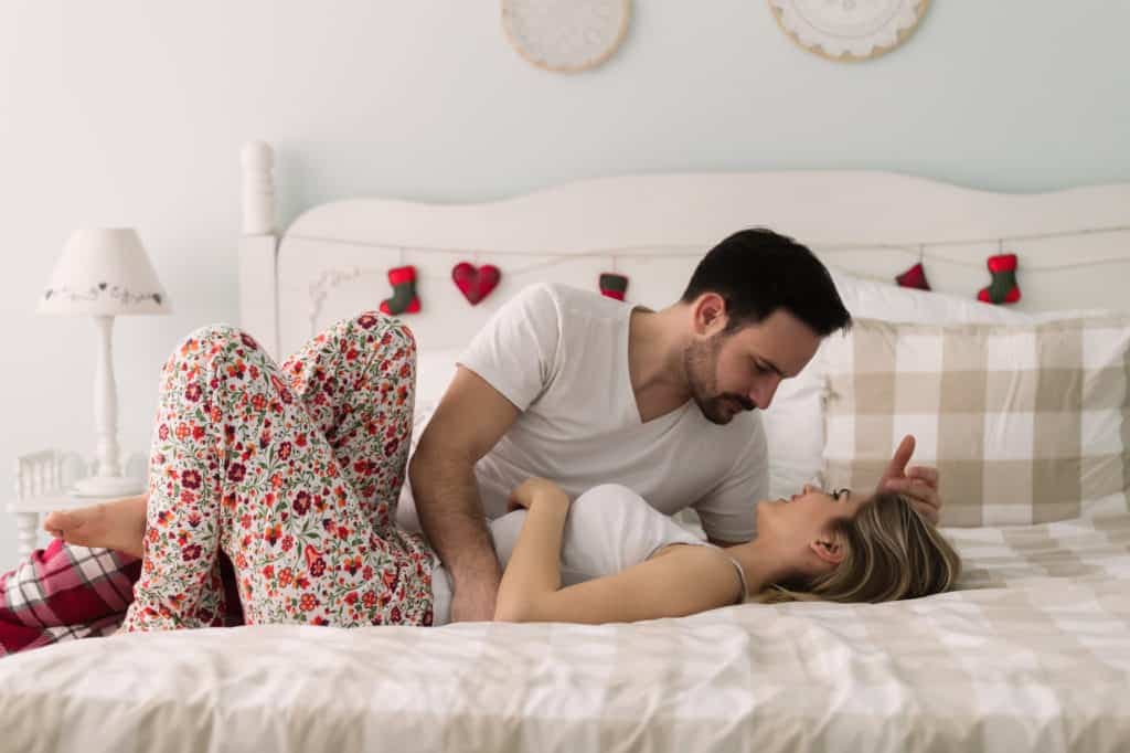 Young attractive happy couple having romantic time in bed