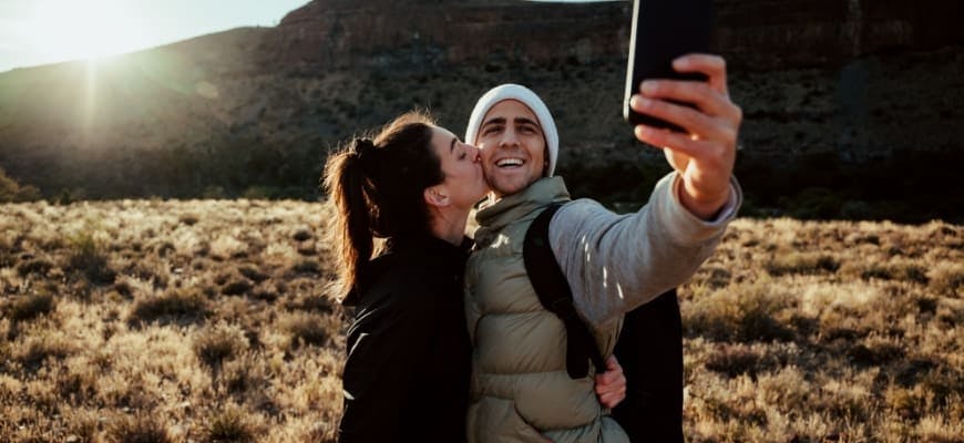 Young adventurous couple taking selfie