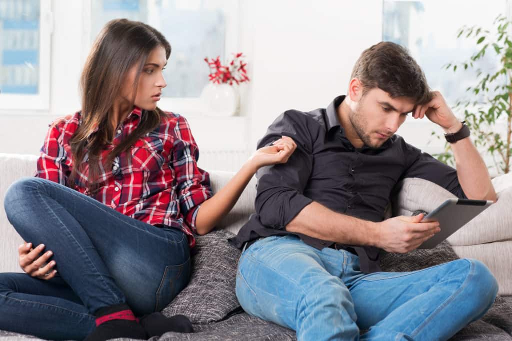 young couple in conflict, male with a tablet in hands