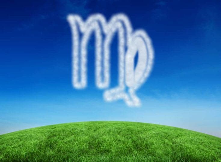 Cloud in shape of virgo star sign against green hill under blue sky