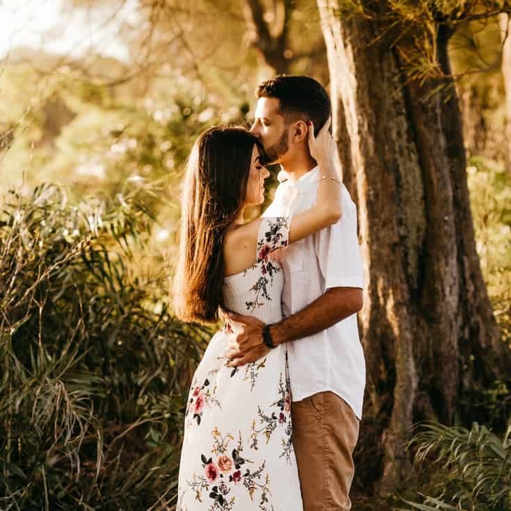 Man kissing the woman on her forehead