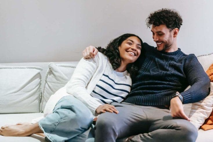 Man and woman cuddling on the couch