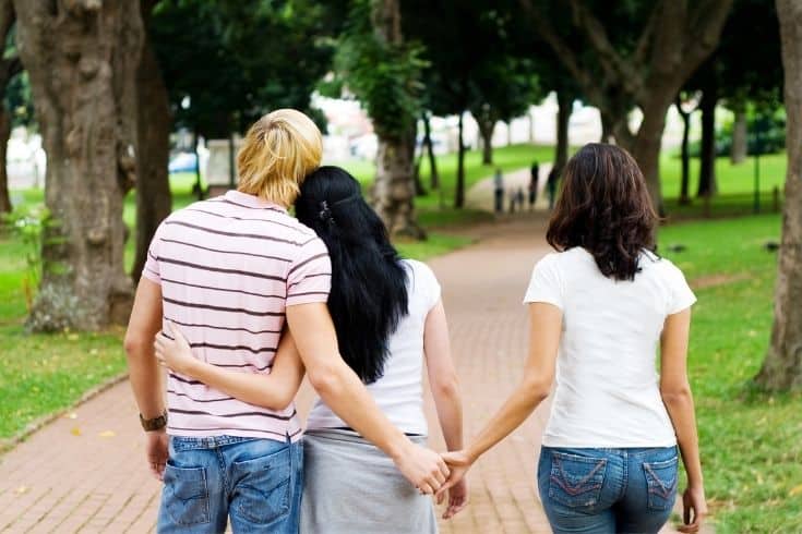 Cheating guy holding the other girls hand