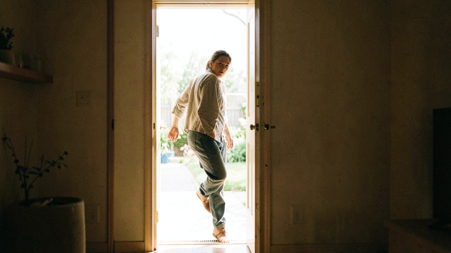 Person stepping from interior shadow into daylight